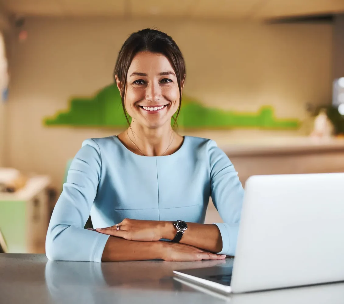 happy-attractive-brunette-virtual-assistant-working-at-the-laptop-in-conference-room