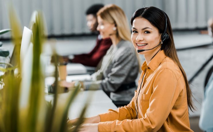 multicultural call center operators with headsets at workpalce in office