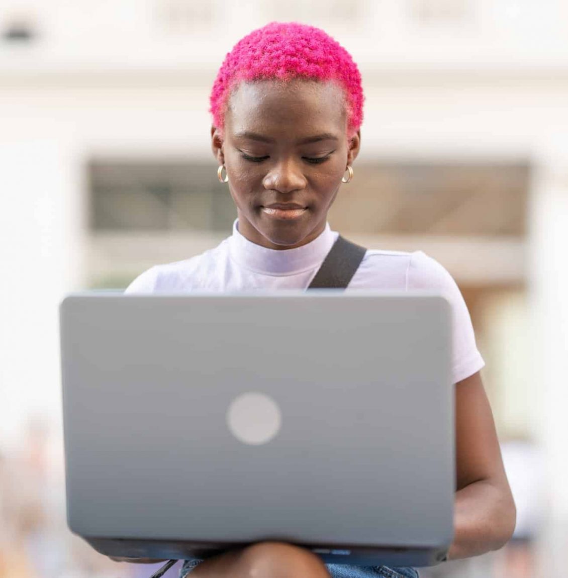 Portrait of a young african woman using the laptop outdoors